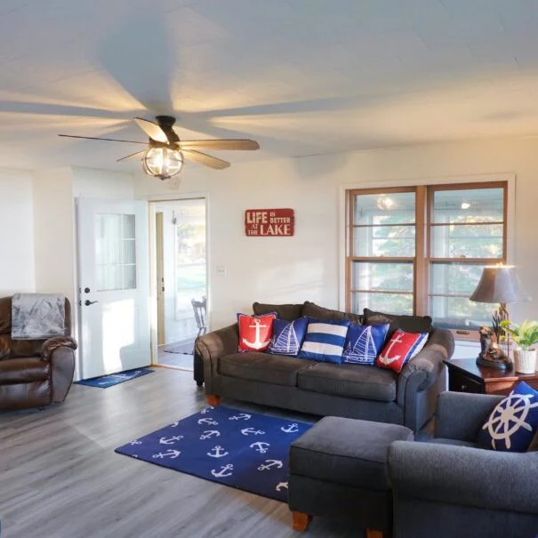 A cozy family room with a couch, chairs, and an entrance to a three-season porch.