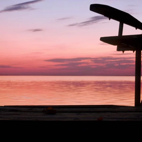 Silhouette of dock chair at dusk over the lake