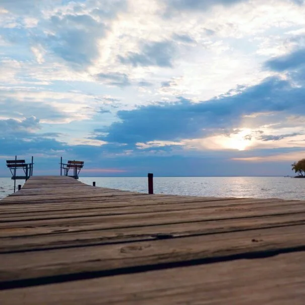 Dock overlooking blue waters with clouds in the sky