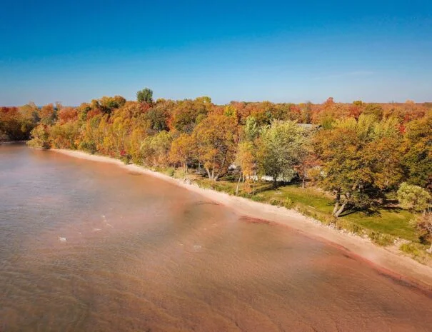 Aerial view of Sunset Shore Mille Lacs beach and surrounding forest during the fall season.