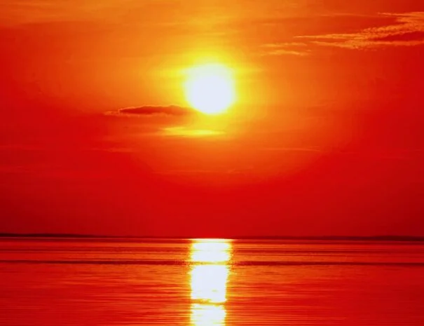 Vibrant red and orange sunset over calm lake