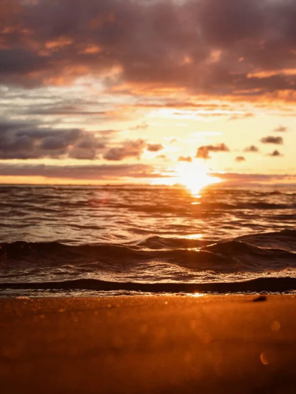 Vibrant sunset over rippling water on a beach